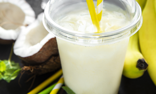 Pina colada alcoholic fresh cocktail served cold with coconut and banana on a black  background